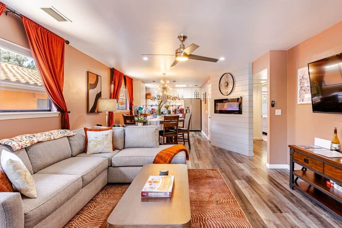 A modern living room with a sectional sofa, a coffee table, and a TV.