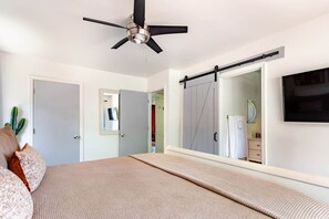 A bedroom with a bed, a ceiling fan, a sliding door, and a television mounted on the wall. - Bicycle House Just Steps to Uptown, Trail Close,, The Bicycle House~ Red Rock Getaway (Sedona)