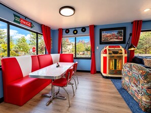 Ein Restaurant im Diner-Stil mit einer Sitzecke, einem Jukebox und Blick nach draußen.