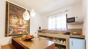 Eine kompakte Küche mit Holzarbeitsplatte, einer Mikrowelle und einem kleinen Kühlschrank.