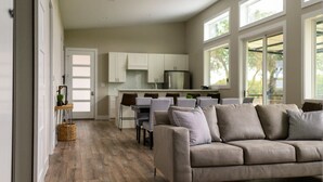 A modern kitchen with white cabinets, a dining area with a table and chairs, and a large window providing natural light. - Modern Farmhouse - Close proximity to Southwest Austin wedding Venues (Austin)