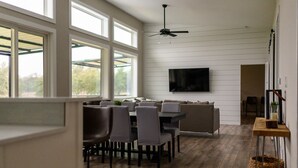 A spacious dining area with a high ceiling, large windows, and a ceiling fan. - Modern Farmhouse - Close proximity to Southwest Austin wedding Venues (Austin)