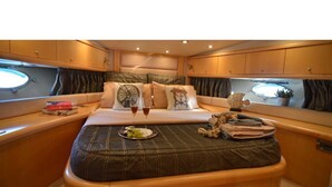 Um interior aconchegante com uma cama, mesa de cabeceira e uma janela.
