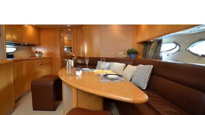 Um espaço interior pequeno e bem iluminado, com área de refeições, sofá e uma cozinha compacta.