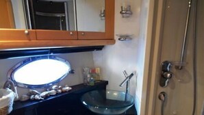 Uma casa de banho compacta com sanita, lavatório e chuveiro.