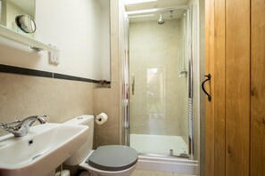 A bathroom with a sink, toilet, and glass-enclosed shower.
