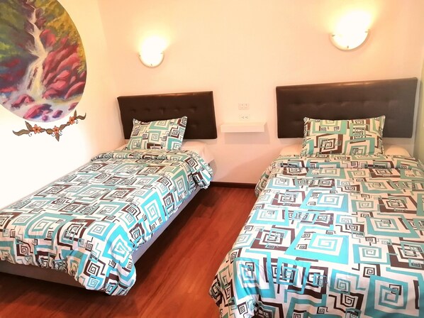 Habitación doble con dos camas, cada una con ropa de cama estampada y cabeceros.
