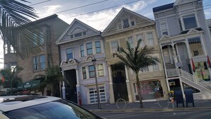 A row of historic buildings with classic architecture, including a visible storefront with a sign.