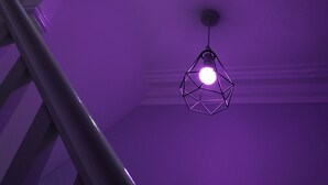 A staircase with a handrail and a geometric pendant light. - The Castleton (Blackpool)