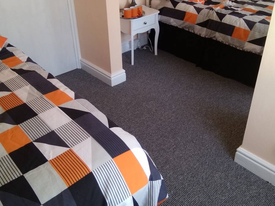 Una habitación de hotel con dos camas, un escritorio pequeño y una silla.