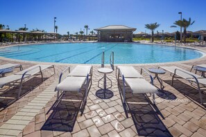A swimming pool with lounge chairs and a covered pavilion.