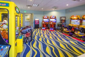 Een kamer met speelautomaten, een grijpkraan en een kamerbreed tapijt.