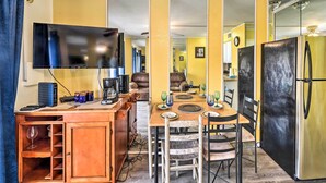 A compact living space with a dining area, kitchenette, and a TV mounted on the wall. - Seaside Corpus Christi Condo at The Villa del Sol! (Corpus Christi)