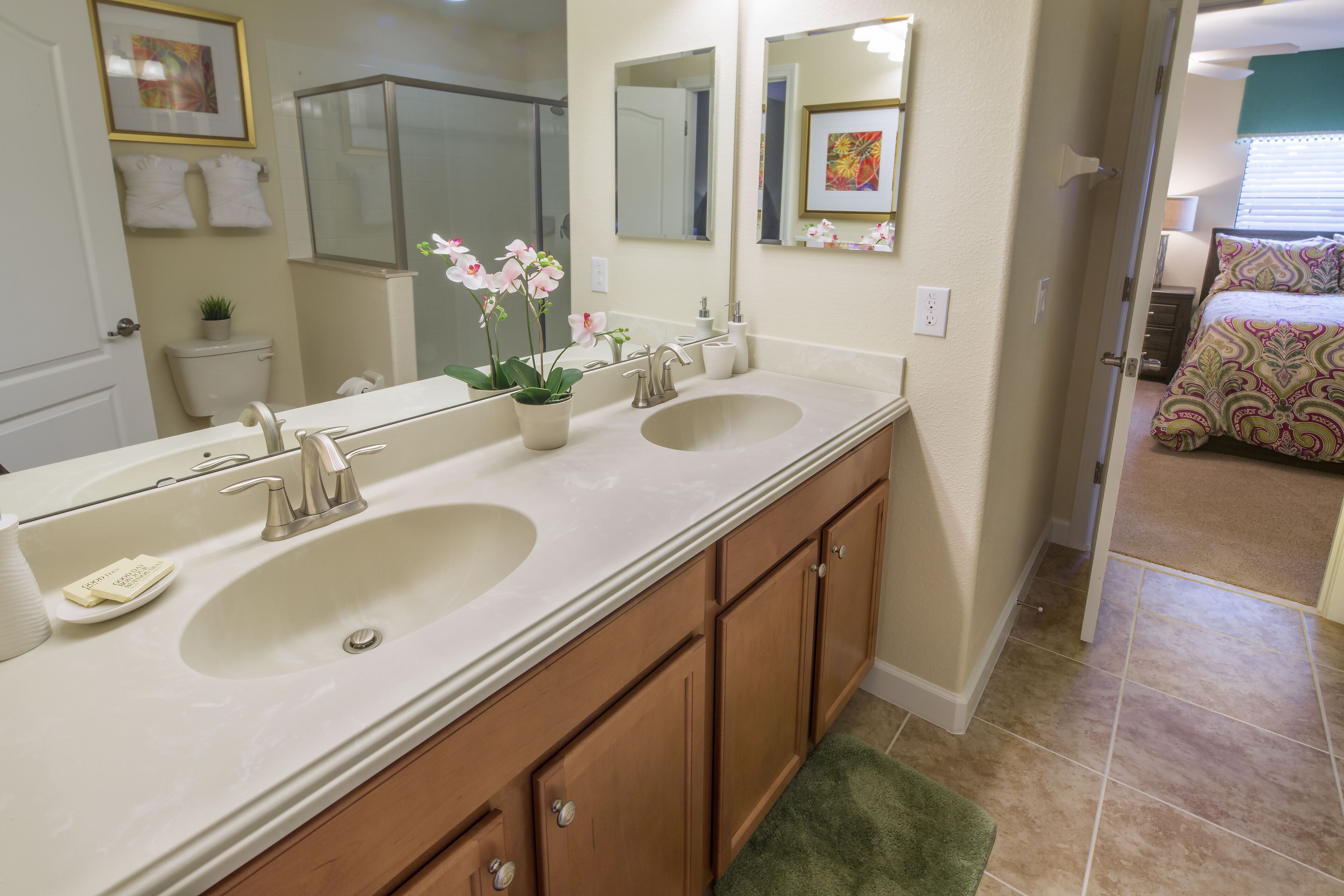 A bathroom with two sinks, a large mirror, and wooden cabinets.