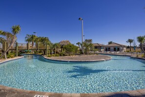 A clear swimming pool with a tiled edge, surrounded by palm trees and a fence. - Sundance Villa by VillaDirect (Kissimmee)
