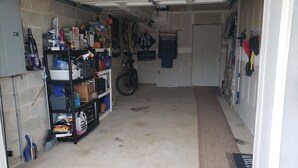 A garage with shelves stocked with cleaning supplies and a bicycle. - Walk to the ocean and Boardwalk (Seaside Park)