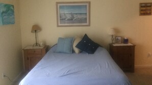 A bedroom with a bed, two nightstands, a ceiling fan, and a framed picture on the wall. - Walk to the ocean and Boardwalk (Seaside Park)