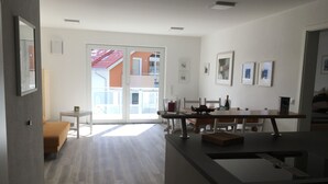 A modern kitchen with a dining area, a large window, and a view of the outside. - Apartment Schönblick (Pfronten-Halden)