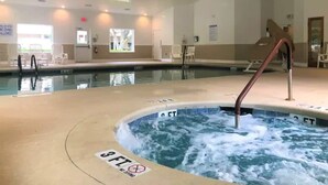 Ett poolområde vid hotellet med två pooler, en bubbelpool och en skylt som förbjuder dykning på ett avstånd av 3 fot.