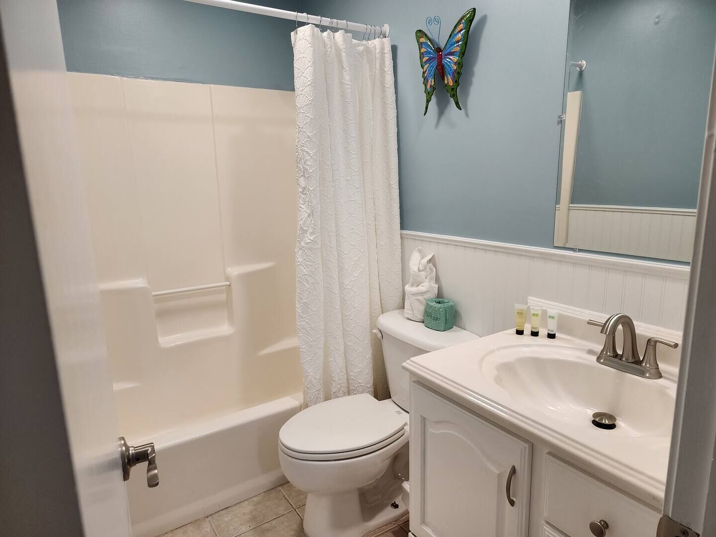 Une salle de bain équipée d’une baignoire, de toilettes, d’un lavabo et d’un miroir.