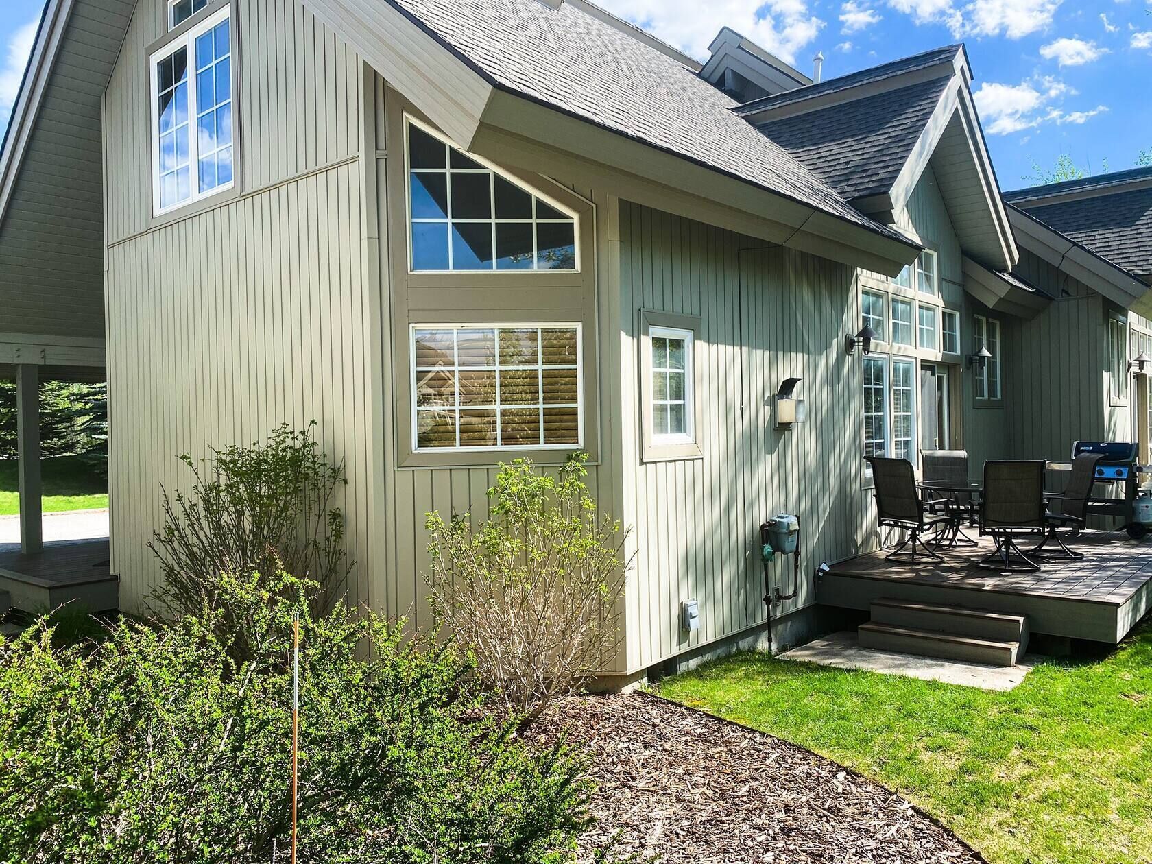 A two-story house with a covered patio and outdoor seating area.