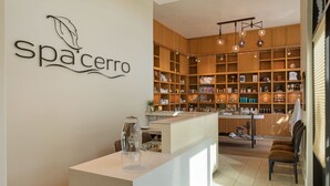 A modern interior with a reception desk, wooden shelving, and a variety of products on display. - HOTEL CERRO, Autograph Collection (San Luis Obispo)