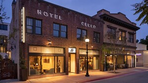A hotel with a brick facade, large windows, and a well-lit entrance. - HOTEL CERRO, Autograph Collection (San Luis Obispo)