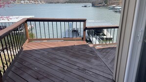 Una terraza de madera con barandilla que da a un lago.