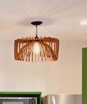 Een moderne keuken met een bijzondere hanglamp en roestvrijstalen apparatuur.