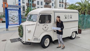 A vintage truck with 'PRALOR DOUGNUTS' branding parked on a sidewalk. - Kauai-Inspired California Beach Retreat, Unit 3 (Oceanside)