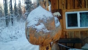 A wooden cabin with a snow-covered exterior and a window. - One bedroom cabin with inside toilet and stand up loft.  PET FRIENDLY! (Talkeetna)