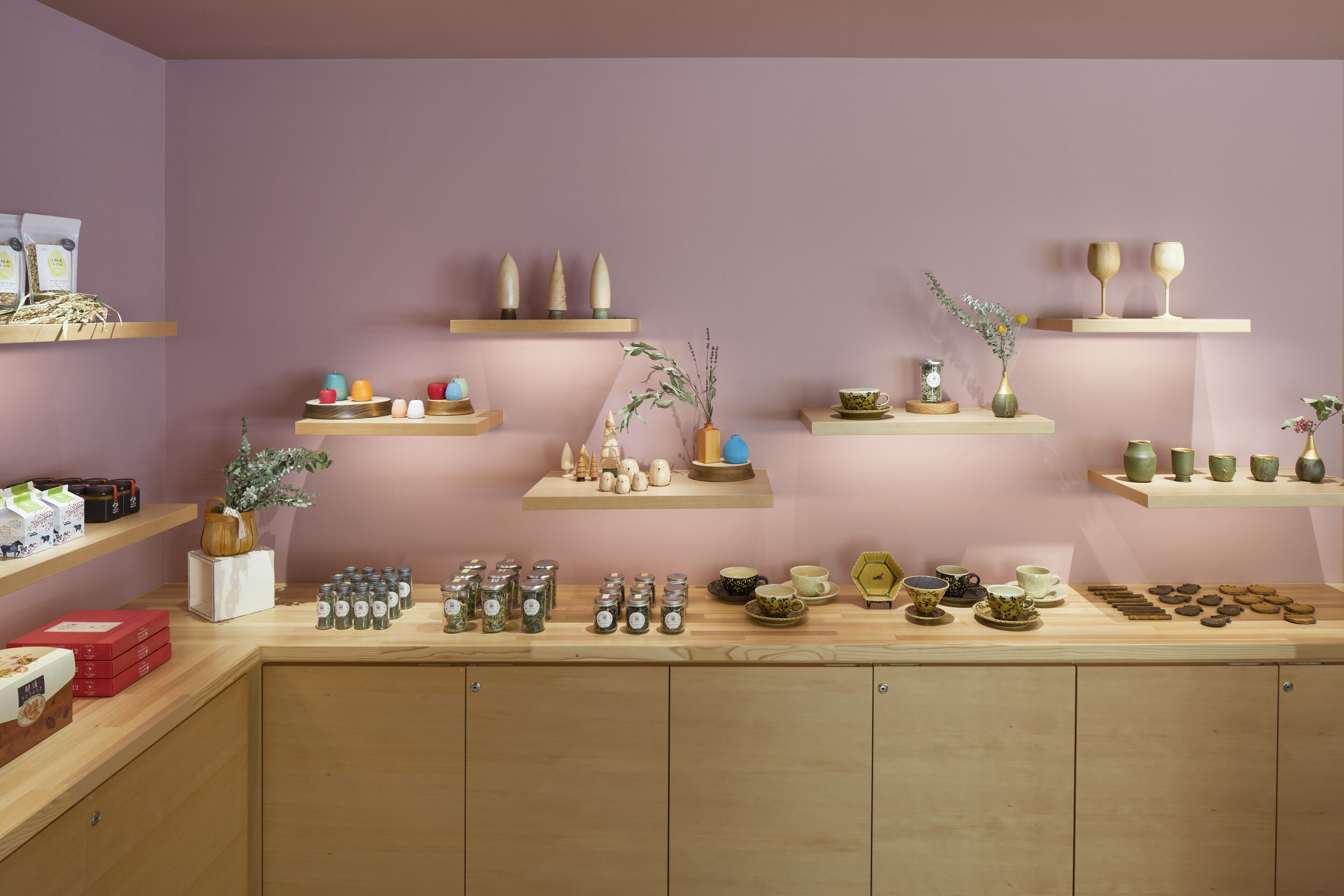 A kitchen with wooden cabinets, shelves with jars, and various kitchenware.