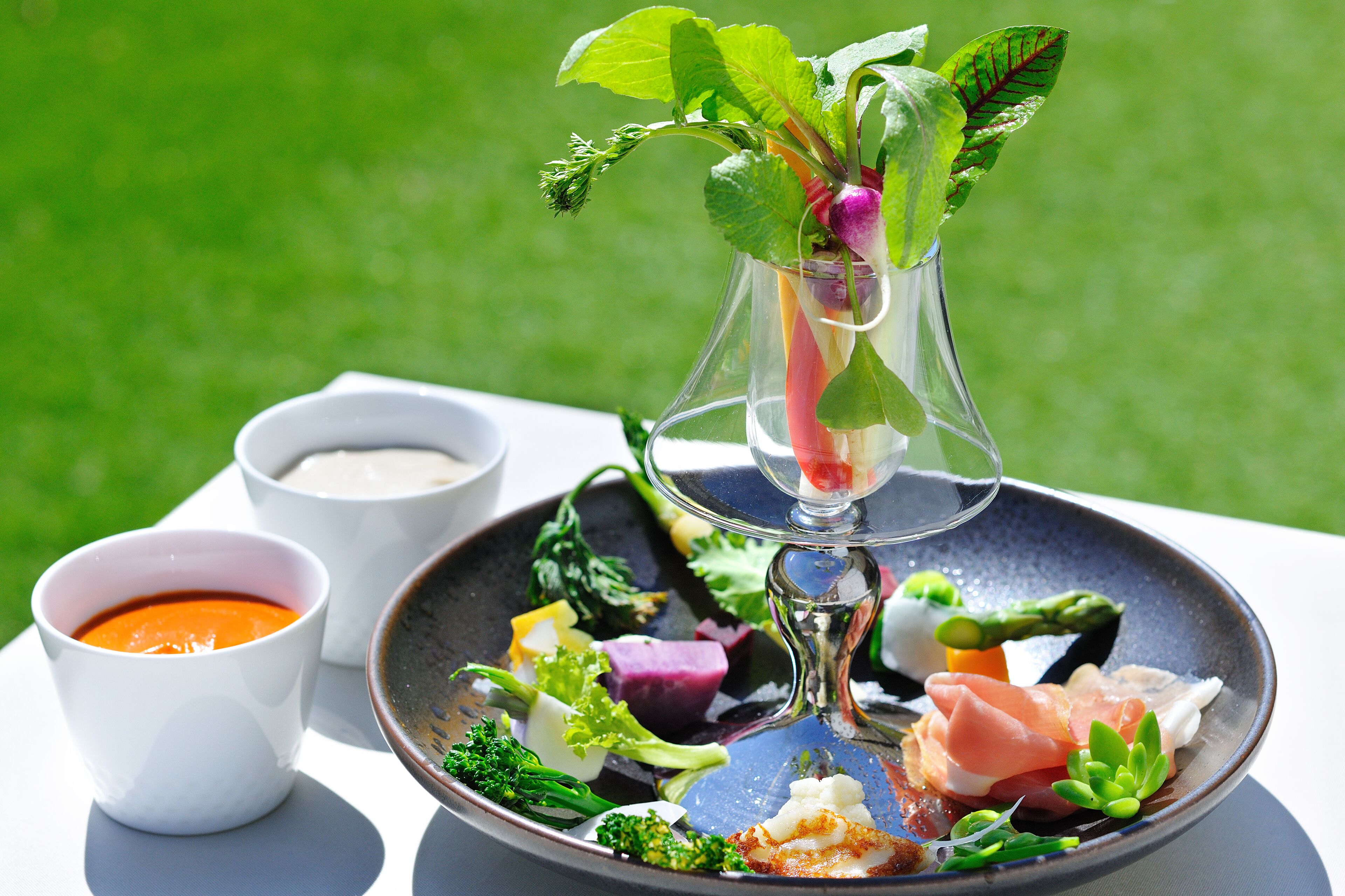A plate of food with various vegetables and a glass of water on a table.