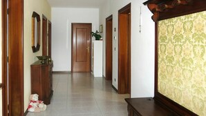 A hallway with wooden doors, a white wall, and a patterned wallpaper on the right. - Nice apartment for 6 guests with WIFI, TV, patio and pets allowed (Eraclea)