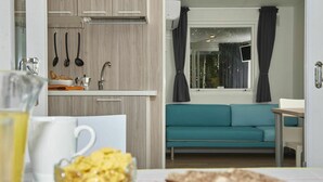 A compact living space with a kitchenette, a dining area, and a sofa. - Nice apartment in villa for 5 guests with WIFI, pool, A/C, TV and terrace (Cellole)