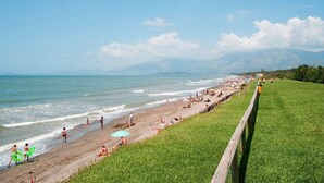 A beach with people, umbrellas, and a grassy area. - Nice apartment in villa for 5 guests with WIFI, pool, A/C, TV and terrace (Cellole)