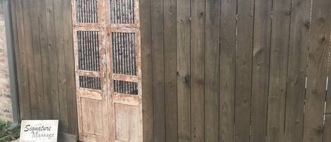 A wooden gate with a sign for a massage service.