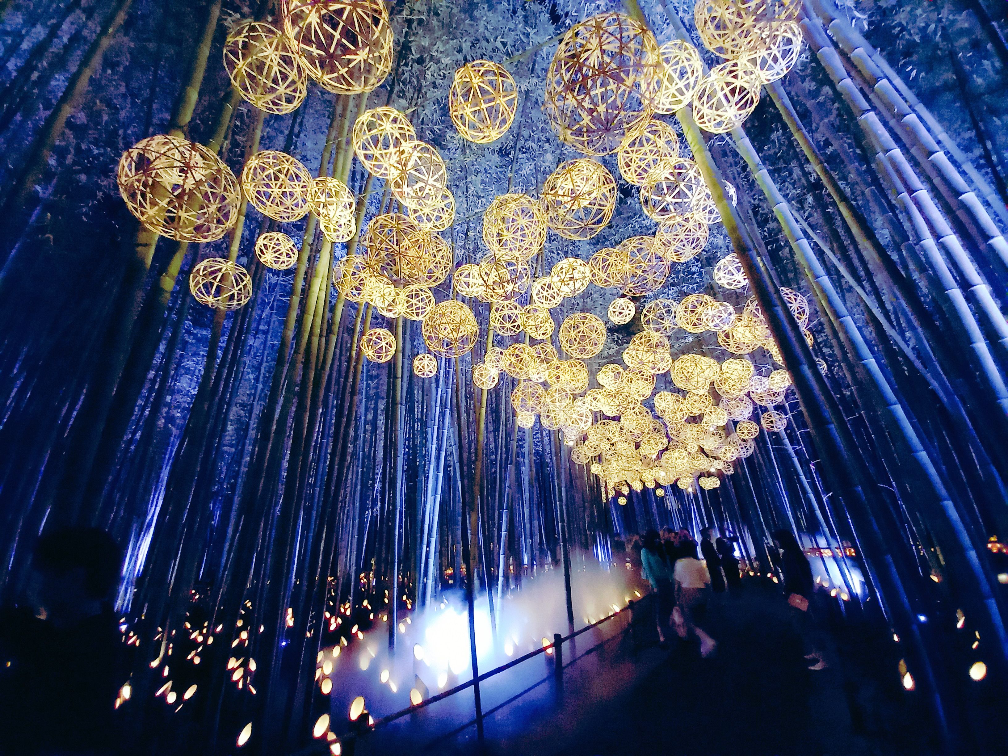 Un lieu dont le plafond est orné de structures sphériques et de faisceaux de lumière verticaux.