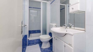Een moderne badkamer met toilet, wastafel en douche.
