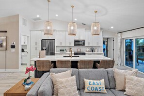 A modern kitchen with white cabinets, stainless steel appliances, and a central island.