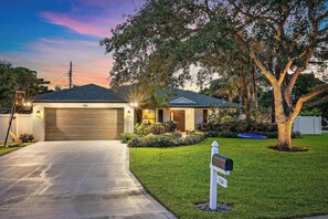 A residential house with a garage, a mailbox, and a well-maintained lawn.