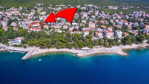 Vue aérienne d’une ville côtière avec une plage, des maisons et une jetée.