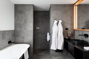 A modern bathroom with a freestanding bathtub, a walk-in shower, and a vanity with a large mirror. - Hotel Verge Launceston (Launceston)
