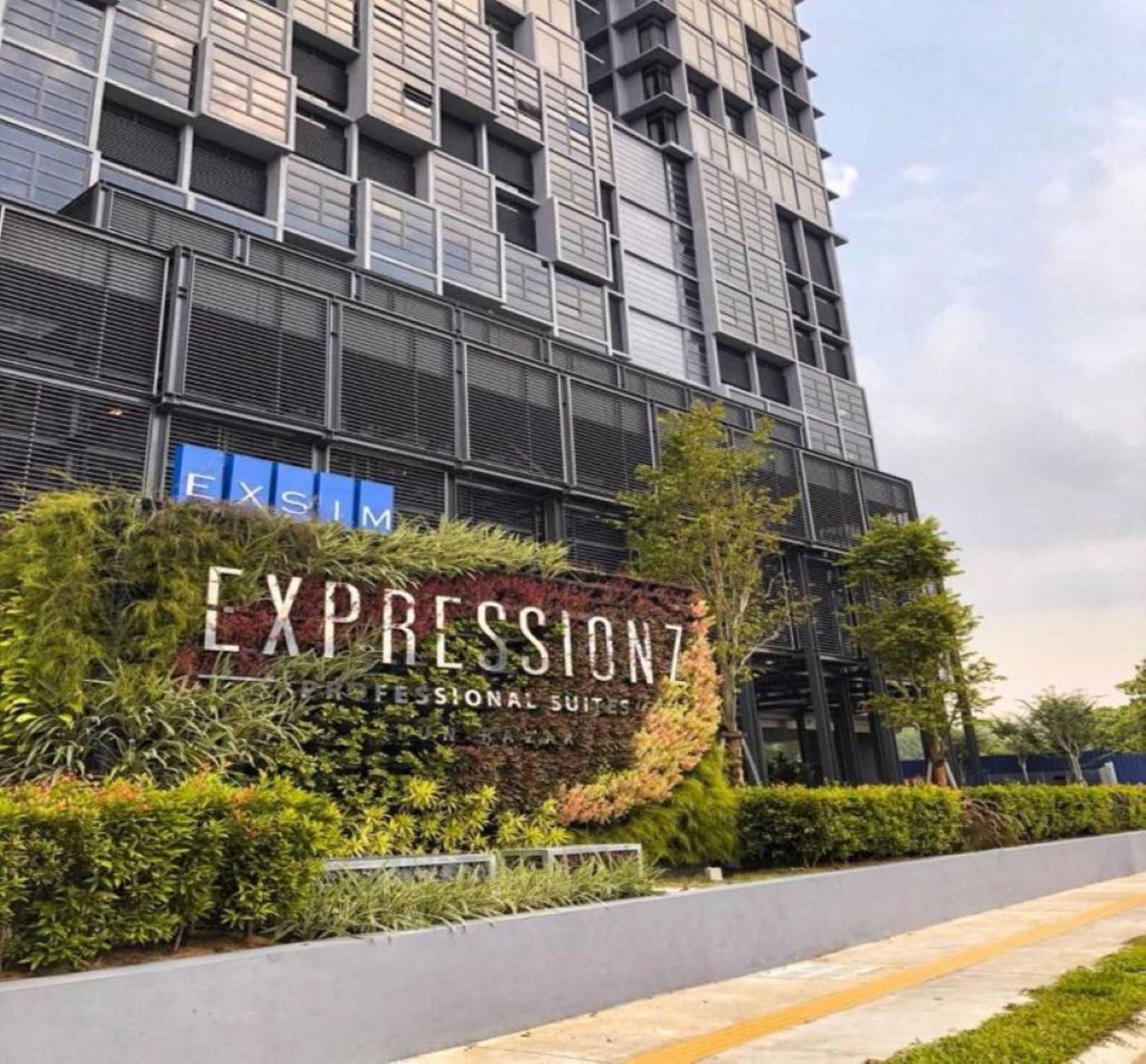 Een modern gebouw met een bord waarop 'Expression Professional Suites' staat.