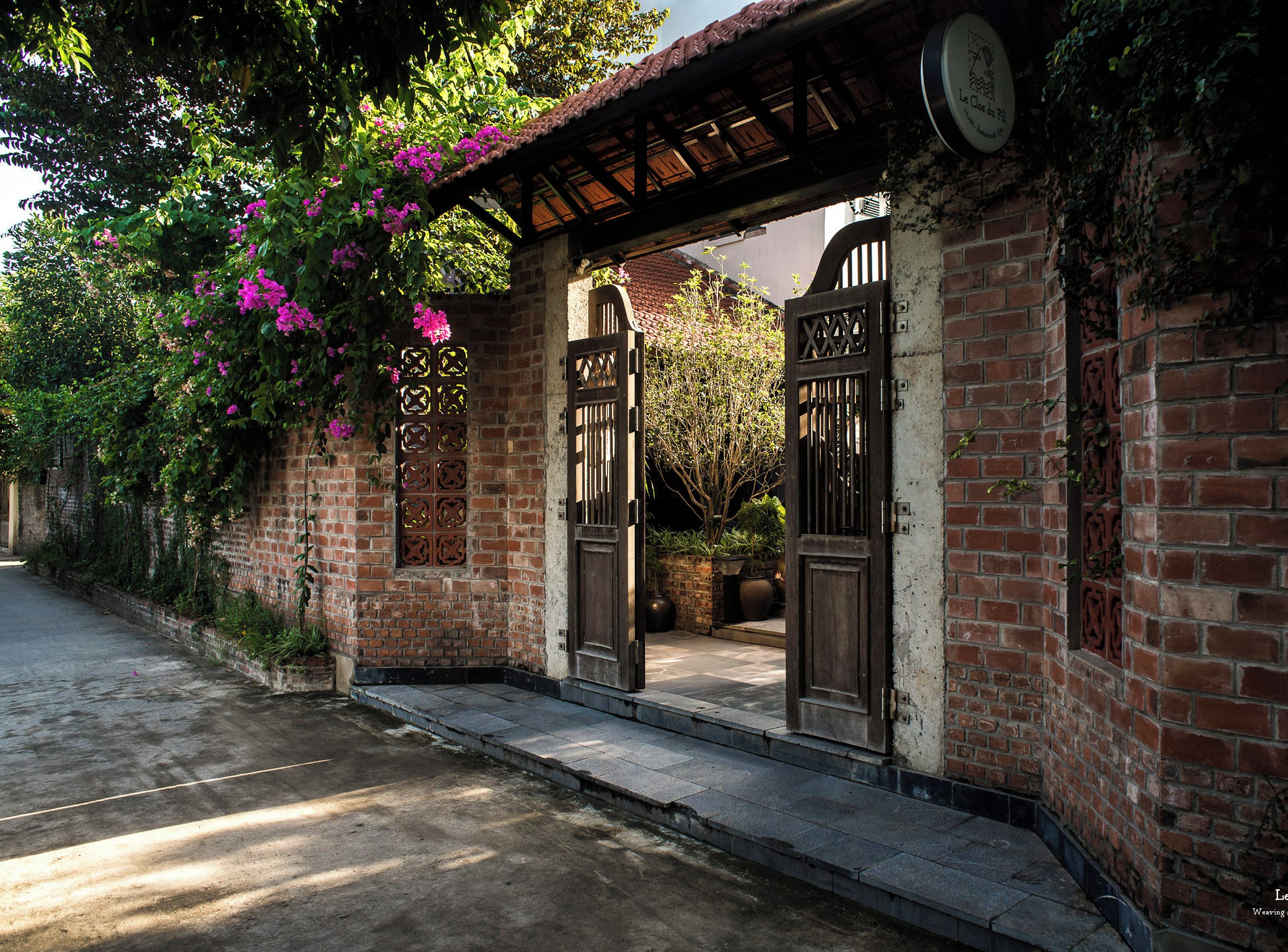 Un edificio de ladrillo con vestíbulo cubierto y jardín.