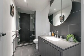 Un bagno moderno con doccia, servizi igienici e lavandino.
