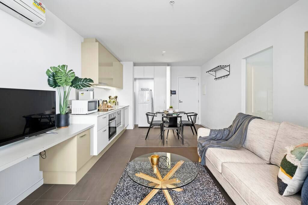 A modern apartment with a kitchen, dining area, and living room.