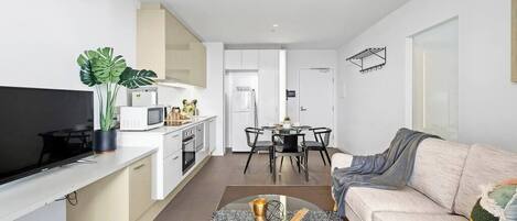 A modern apartment with a kitchen, dining area, and living room.