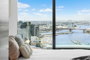 A city view from a high-rise hotel room with a large window overlooking a river and a bridge. - LILLY - Sky High Stunner POOL GYM (Richmond)