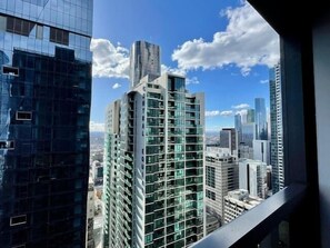 Un immeuble de grande hauteur doté d’une façade moderne en verre, entouré d’autres bâtiments imposants.